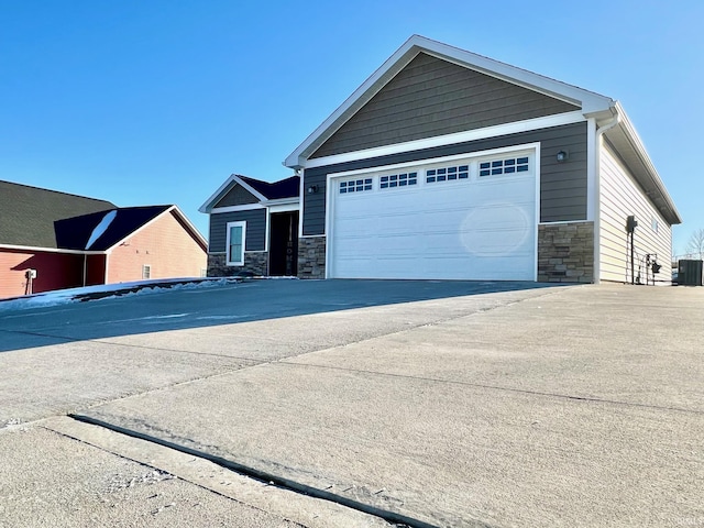 view of front of home featuring a garage and central air condition unit