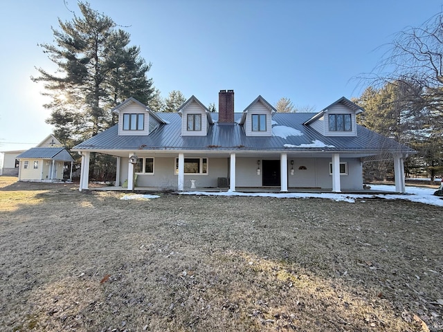 cape cod-style house with covered porch and a front lawn