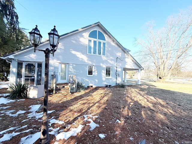 snow covered house featuring a sunroom