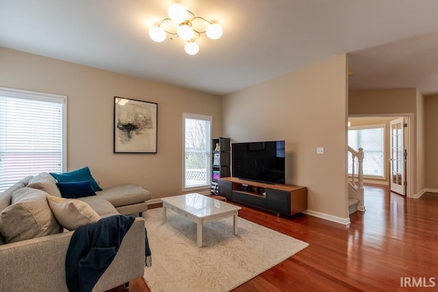 living room featuring an inviting chandelier and dark hardwood / wood-style flooring