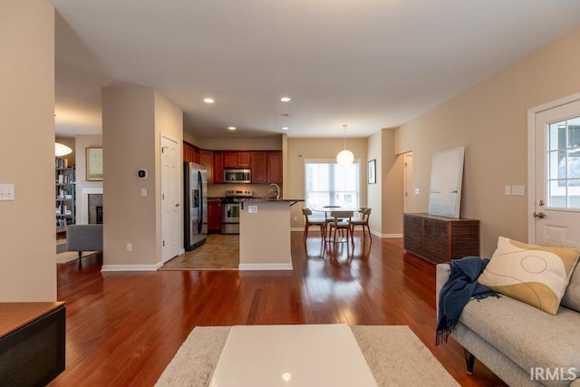 living room featuring plenty of natural light, dark hardwood / wood-style floors, and sink