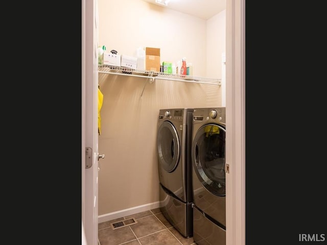 laundry area with washing machine and dryer and tile patterned floors