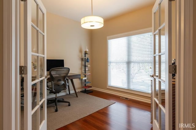 office with dark hardwood / wood-style floors and french doors