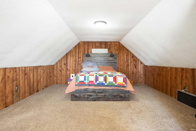 carpeted bedroom with lofted ceiling, a textured ceiling, and wood walls