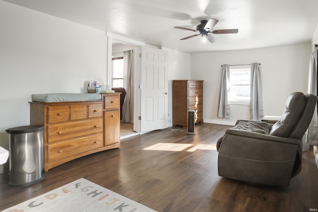 living area featuring ceiling fan and dark hardwood / wood-style floors