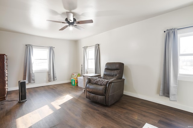 living area featuring ceiling fan and dark hardwood / wood-style flooring