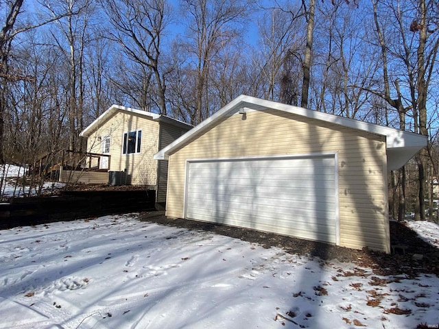 view of snowy exterior with a garage and an outdoor structure