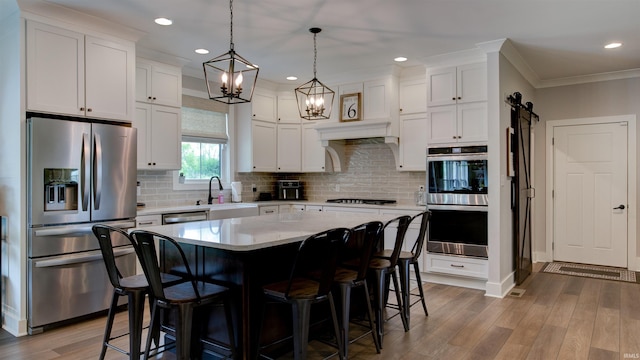 kitchen featuring white cabinetry, appliances with stainless steel finishes, a center island, and sink