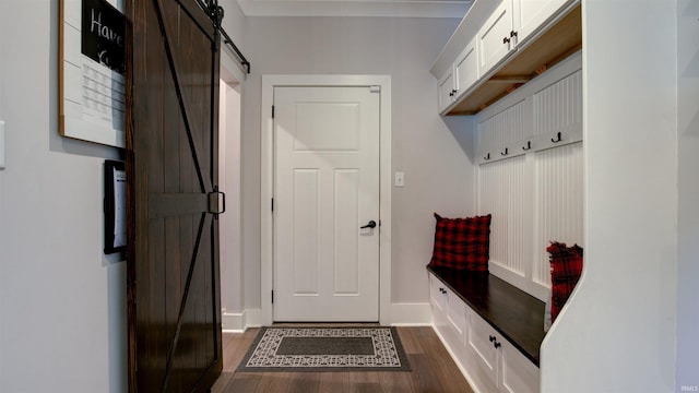 mudroom with dark wood-type flooring and a barn door