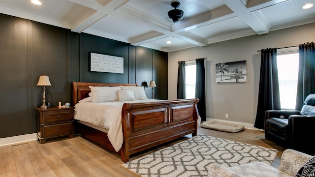 bedroom featuring coffered ceiling, ceiling fan, light hardwood / wood-style floors, crown molding, and beam ceiling