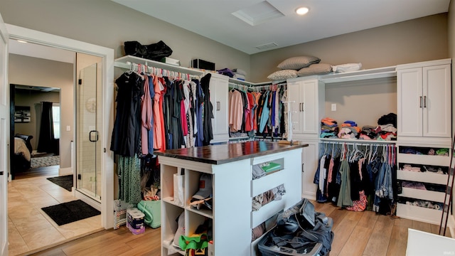 walk in closet with light hardwood / wood-style flooring