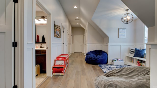 bonus room with a notable chandelier and hardwood / wood-style flooring