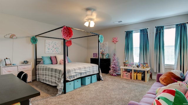 carpeted bedroom featuring ceiling fan and multiple windows