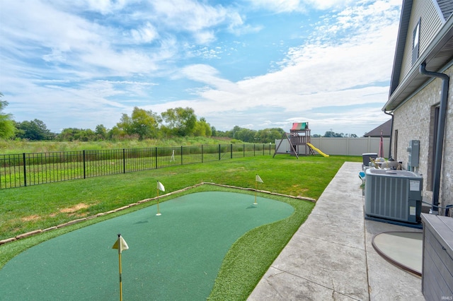 exterior space with a patio area, a lawn, a playground, and central air condition unit