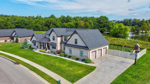 view of front of house with a garage, a front yard, and a water view