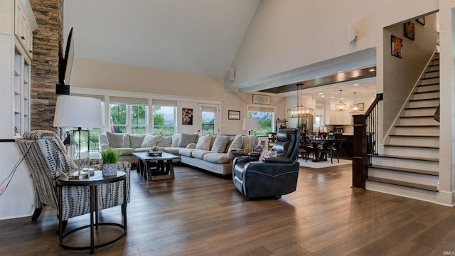 living room with an inviting chandelier, dark hardwood / wood-style floors, and high vaulted ceiling