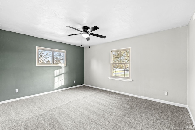 unfurnished room featuring a healthy amount of sunlight, ceiling fan, and carpet flooring