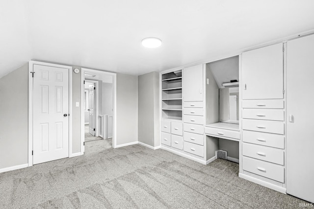 unfurnished bedroom with light colored carpet and lofted ceiling