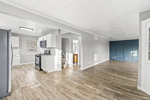 unfurnished living room with crown molding and light wood-type flooring