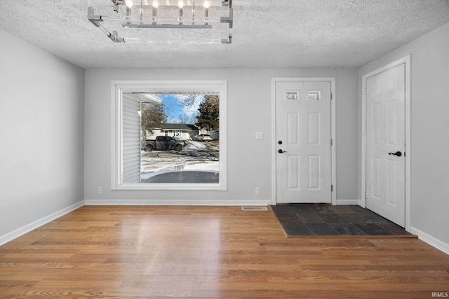 entrance foyer with hardwood / wood-style flooring and a textured ceiling