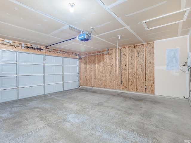 garage with a garage door opener and electric panel