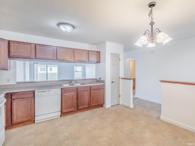 kitchen with a notable chandelier, sink, white appliances, a textured ceiling, and pendant lighting