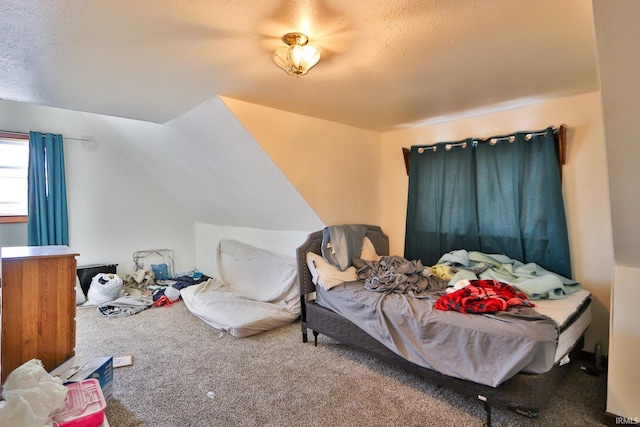 carpeted bedroom with vaulted ceiling and a textured ceiling