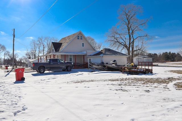 snow covered property featuring an outbuilding