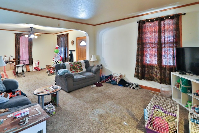 carpeted living room featuring ceiling fan, ornamental molding, and a textured ceiling