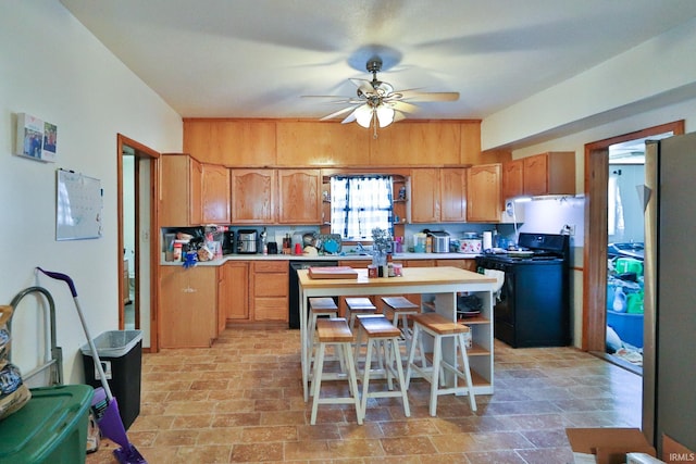 kitchen featuring sink, black appliances, ceiling fan, and a kitchen bar