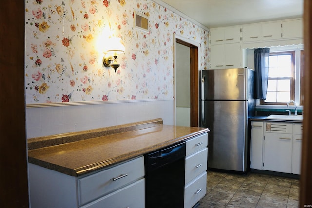 kitchen with white cabinetry, stainless steel fridge, black dishwasher, and sink