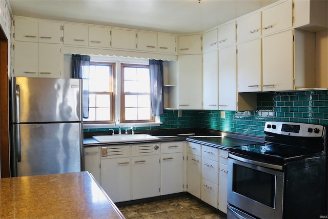 kitchen with stainless steel appliances, white cabinetry, sink, and backsplash