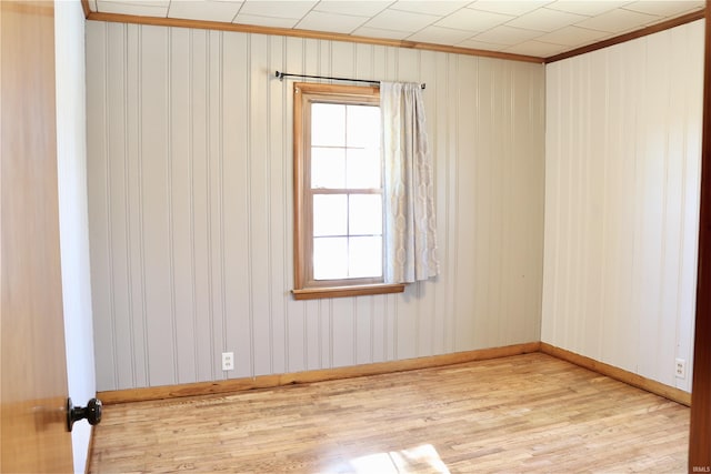 unfurnished room with ornamental molding and light wood-type flooring