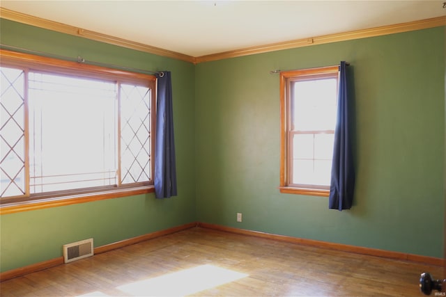 spare room with hardwood / wood-style floors and ornamental molding