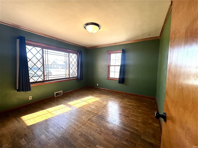 spare room with crown molding and hardwood / wood-style flooring