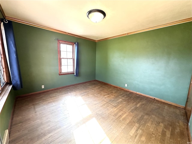 unfurnished room with hardwood / wood-style flooring and ornamental molding