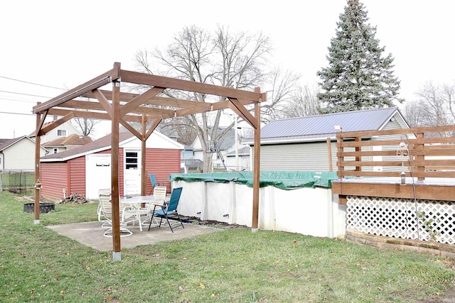 view of yard with a pool side deck and an outbuilding