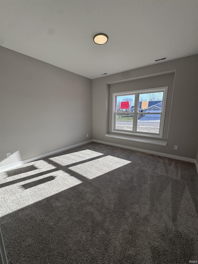 carpeted empty room featuring visible vents and baseboards
