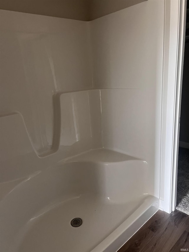 bathroom with walk in shower and wood finished floors