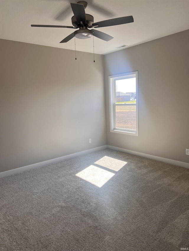 carpeted empty room featuring baseboards, ceiling fan, and visible vents