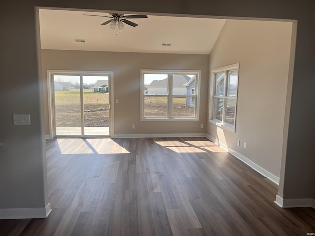 unfurnished room featuring baseboards, visible vents, a wealth of natural light, and vaulted ceiling