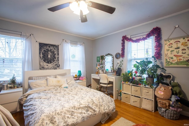 bedroom featuring multiple windows, ornamental molding, and ceiling fan