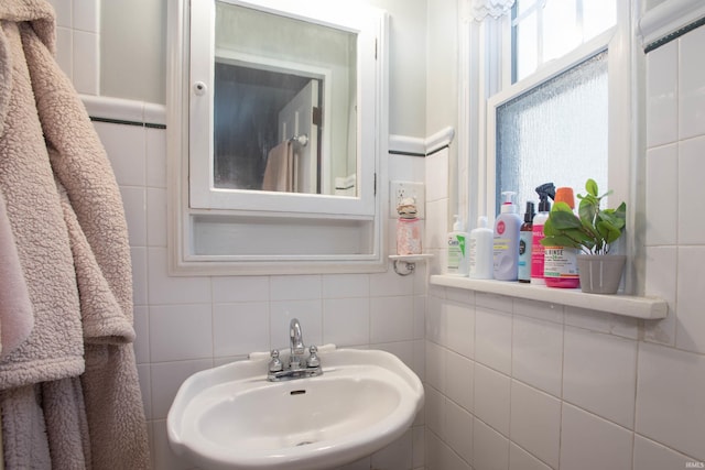 bathroom featuring tile walls and sink