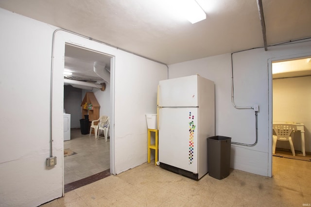 basement with washer / dryer and white fridge