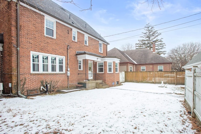 view of snow covered back of property