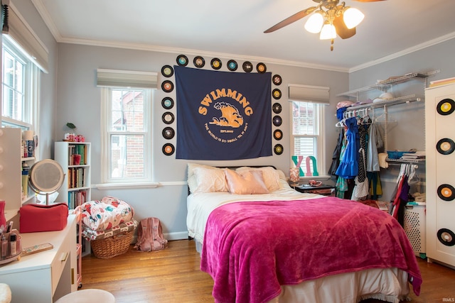 bedroom featuring ornamental molding, a closet, ceiling fan, and light wood-type flooring