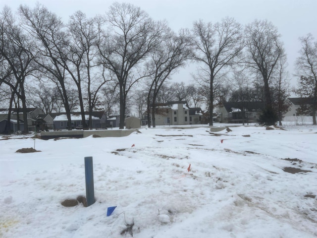 snowy yard featuring a garage and a residential view