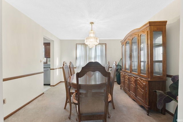 dining room featuring a textured ceiling, light colored carpet, and a chandelier