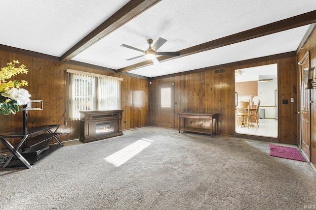 carpeted living room with ceiling fan, a textured ceiling, and beam ceiling