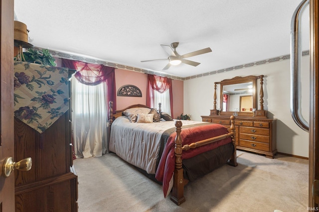 bedroom featuring multiple windows, light colored carpet, a textured ceiling, and ceiling fan